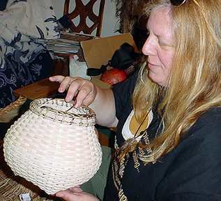Lynn Hoyt looks at a cat's head basket Audrey made.